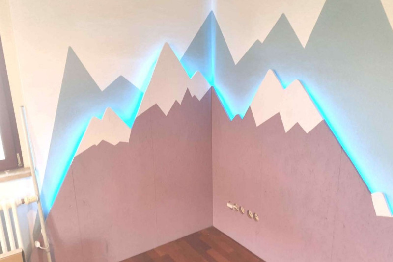 Kinderzimmer mit beleuchteten Bergen in den Farbtönen Königsflieder und Eisenherz
