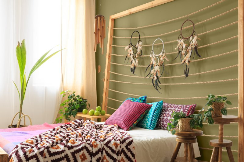 Ethno Einrichtungsstil – Bett mit bunten Kissen und Decken.