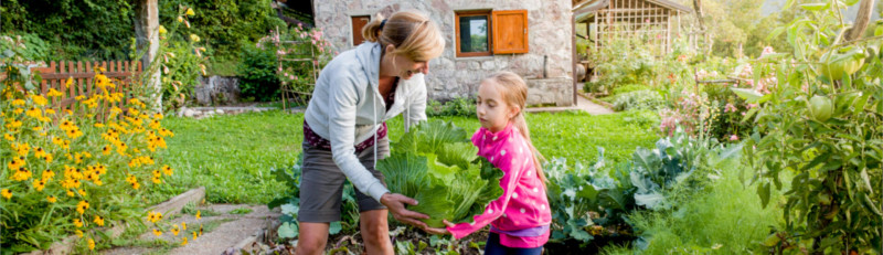 Eine Mutter mit Tochter bei der Gartenarbeit.