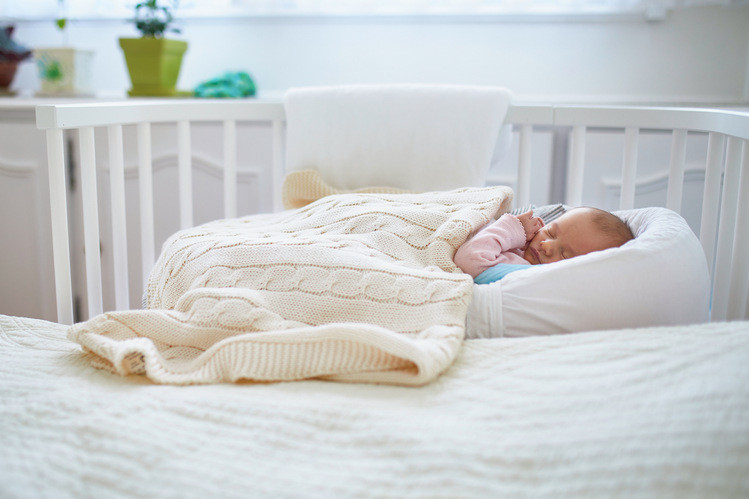 Beistellbett im Elternschlafzimmer: Neugeborenes schläft im Beistellbett