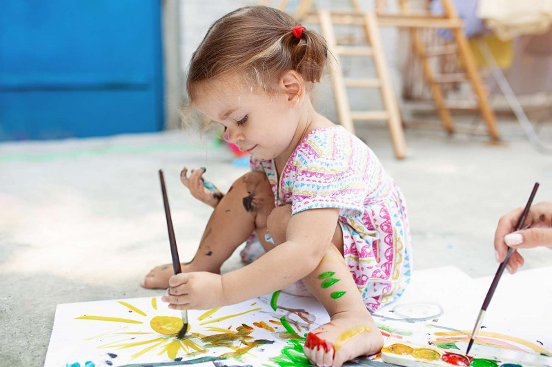 Kinderzimmer - Kind spielt mit Farben