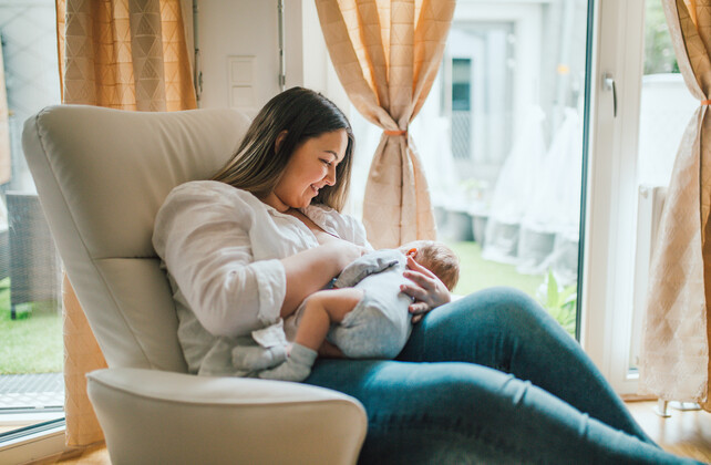 Mutter stillt ihr Baby in einem bequemen Stillsessel